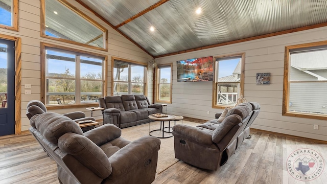 living area featuring vaulted ceiling, light wood-style flooring, and baseboards