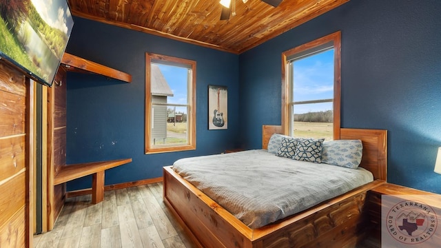 bedroom with wooden ceiling, light wood-style flooring, and baseboards