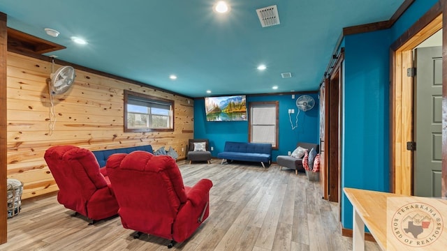 home theater room with a barn door, wood finished floors, visible vents, and recessed lighting