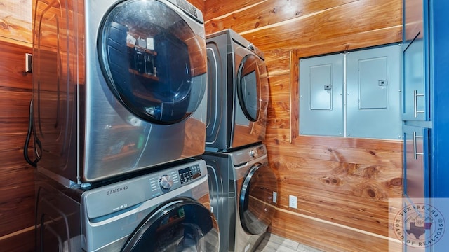 laundry room with laundry area, electric panel, and stacked washer and clothes dryer