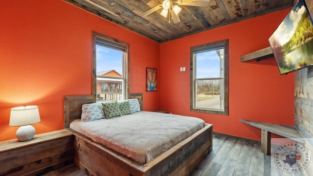 bedroom with dark wood-style floors, wooden ceiling, and a ceiling fan