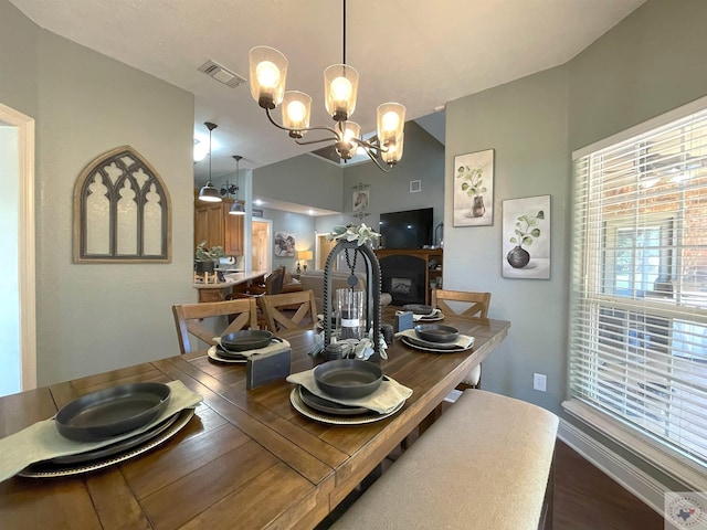 dining space with a chandelier, a fireplace, and wood-type flooring