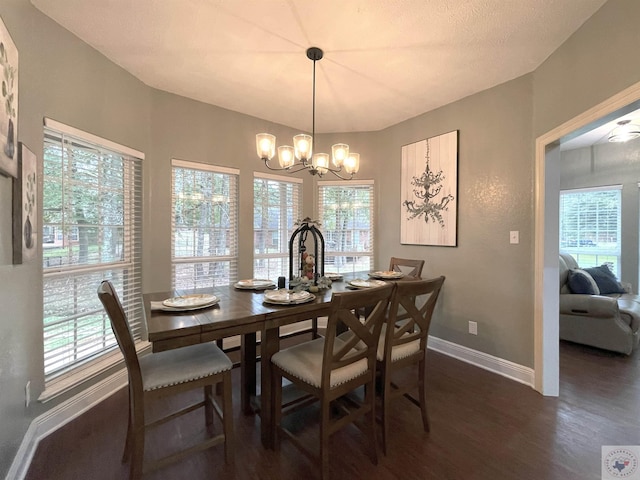 dining room with a healthy amount of sunlight, a notable chandelier, and dark hardwood / wood-style flooring