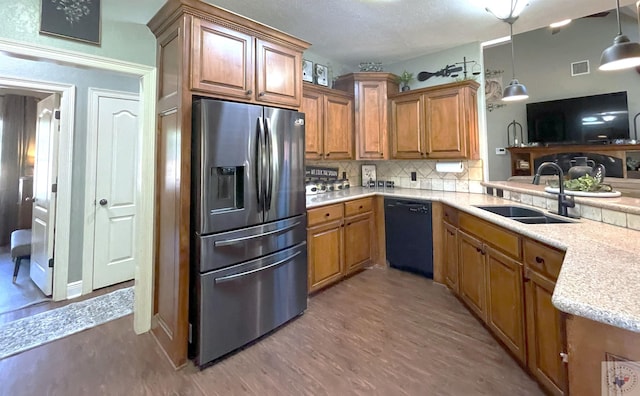 kitchen featuring black dishwasher, stainless steel fridge with ice dispenser, sink, pendant lighting, and dark hardwood / wood-style floors