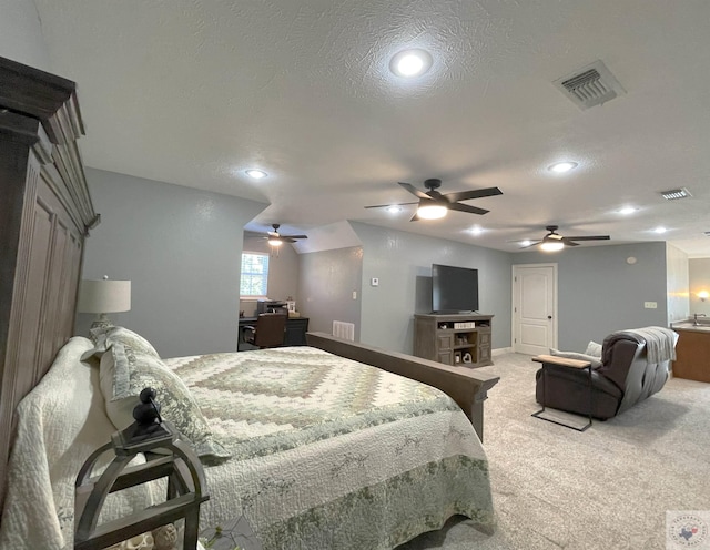 bedroom with light carpet and a textured ceiling