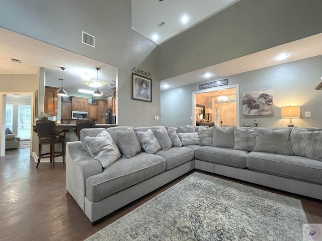 living room with dark wood-type flooring and high vaulted ceiling