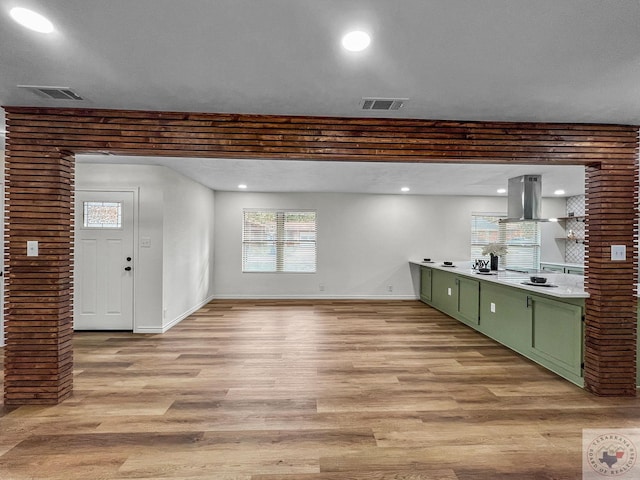 interior space featuring light hardwood / wood-style flooring, green cabinets, and island exhaust hood