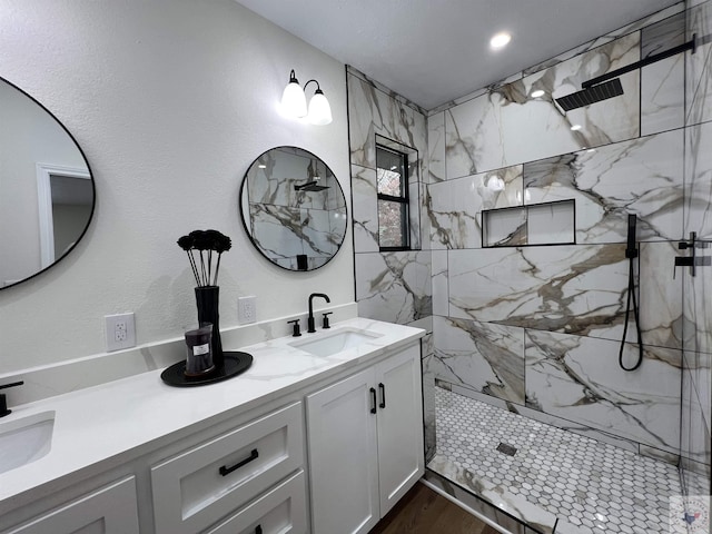 bathroom with vanity, tiled shower, and wood-type flooring