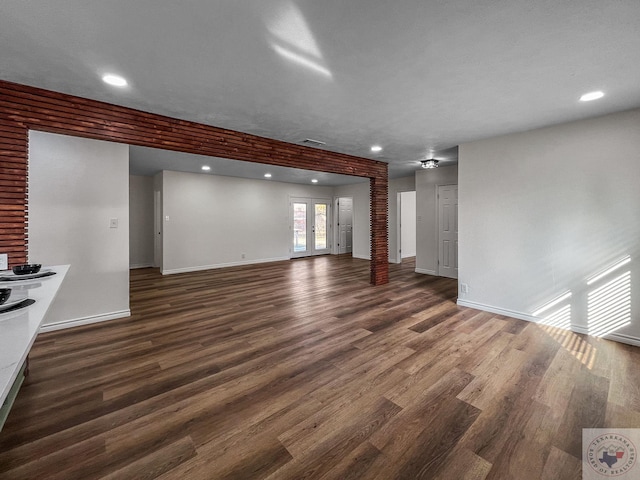 unfurnished living room featuring french doors and dark hardwood / wood-style flooring