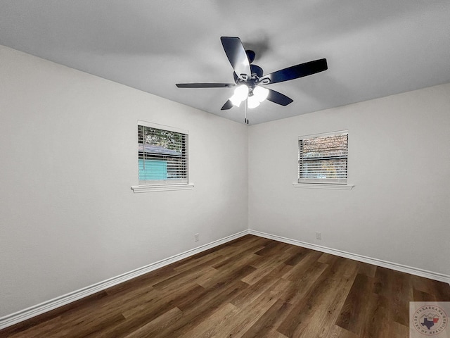 empty room with ceiling fan and dark hardwood / wood-style flooring