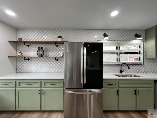 kitchen featuring sink, hardwood / wood-style flooring, stainless steel refrigerator, and green cabinetry