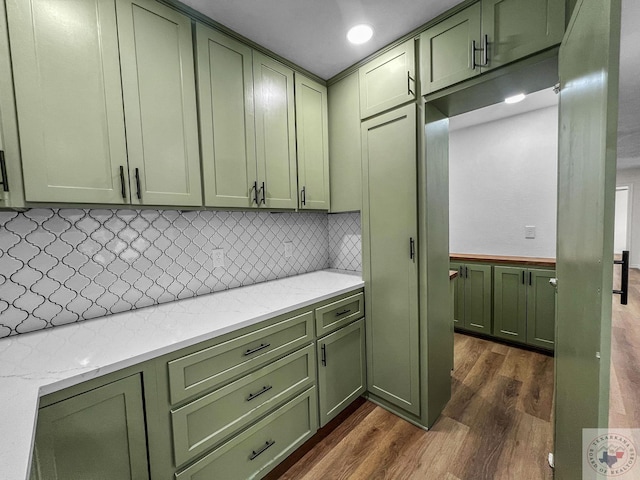 kitchen featuring decorative backsplash, green cabinetry, and dark hardwood / wood-style flooring