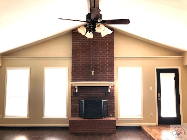 unfurnished living room featuring a fireplace, vaulted ceiling, ceiling fan, and dark hardwood / wood-style flooring