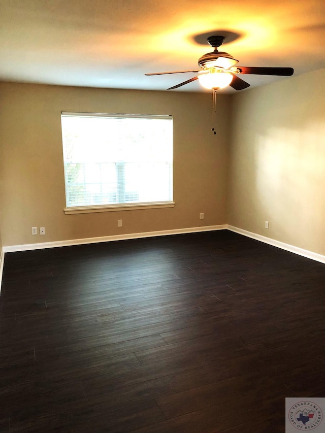 empty room with ceiling fan and dark hardwood / wood-style flooring