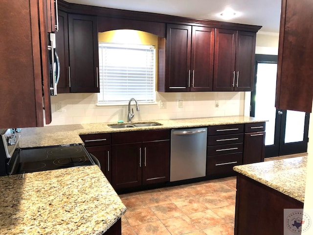 kitchen featuring a wealth of natural light, decorative backsplash, sink, stainless steel appliances, and light stone counters