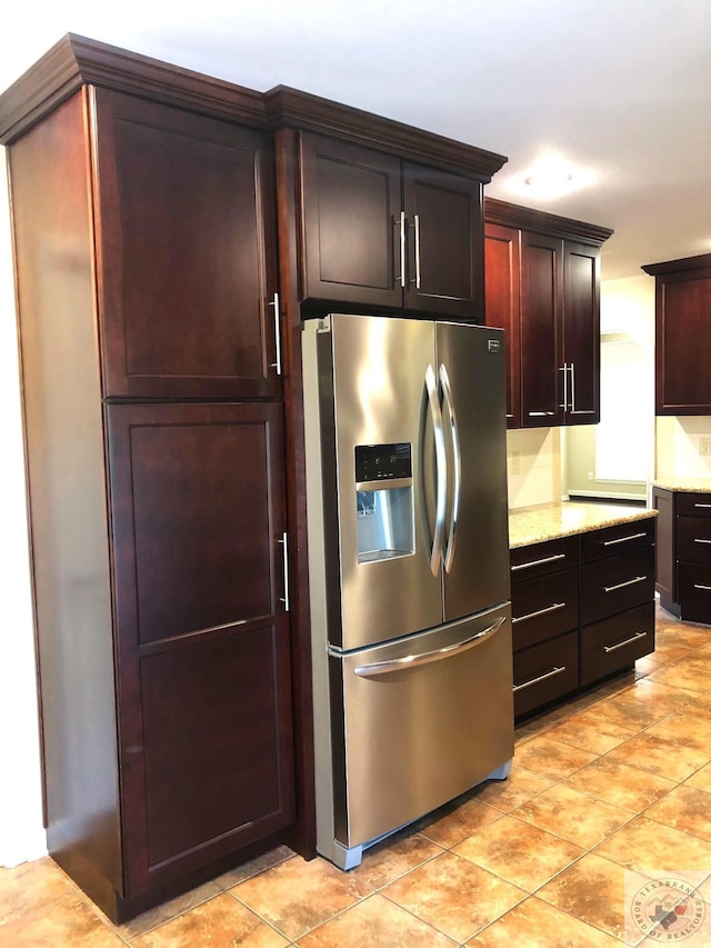 kitchen with stainless steel fridge with ice dispenser and light stone counters