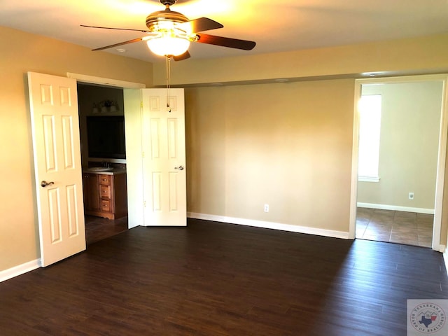 empty room with sink, ceiling fan, and dark hardwood / wood-style flooring