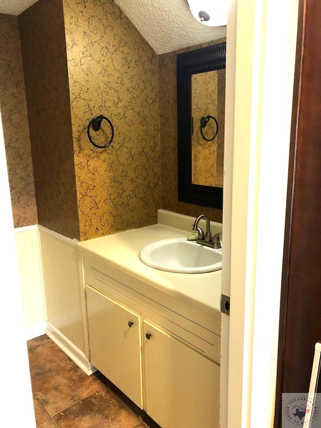 bathroom featuring a textured ceiling and vanity