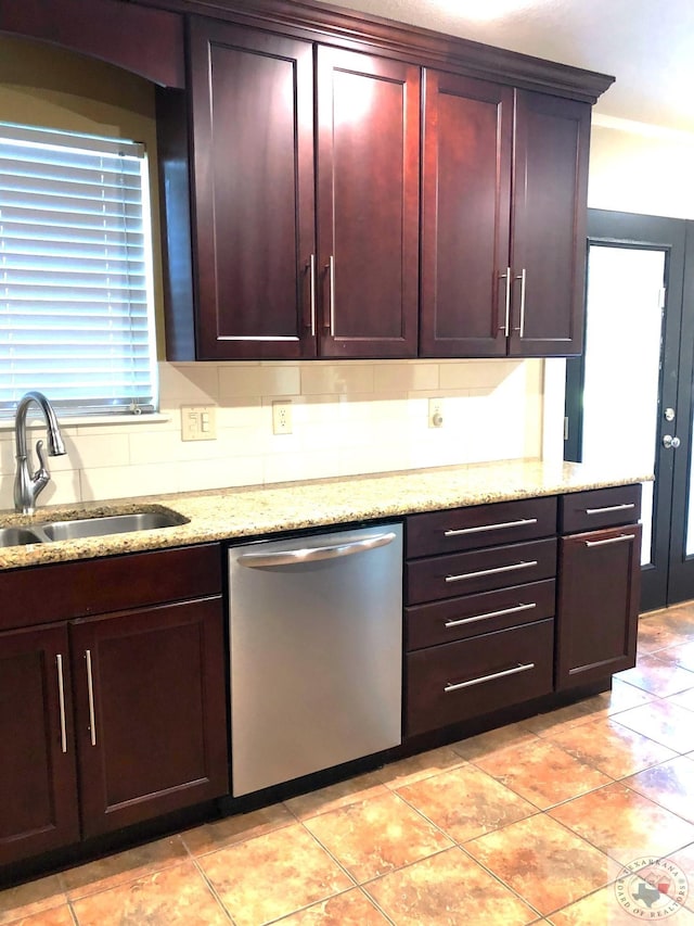 kitchen featuring light stone countertops, sink, and stainless steel dishwasher