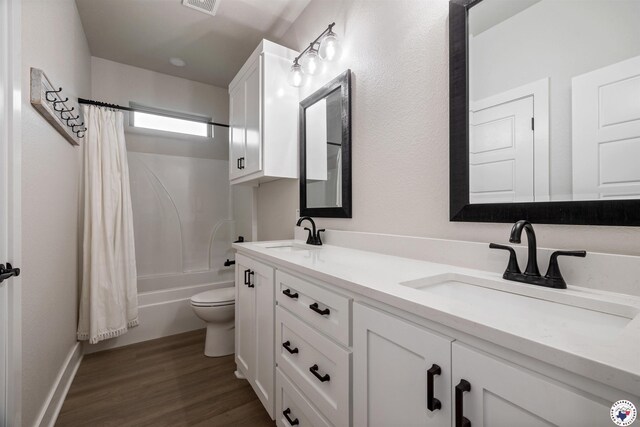 8409 Mandarin Cv, Texarkana, TX 75503 - bathroom with double vanity, toilet, shower / bath combo, wood finished floors, and baseboards