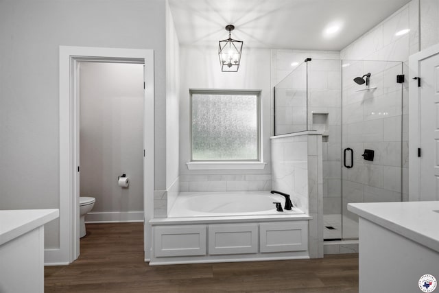 8409 Mandarin Cv, Texarkana, TX 75503 - bathroom featuring a garden tub, vanity, toilet, a stall shower, and wood finished floors
