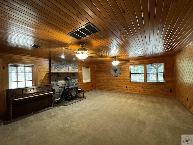 carpeted living room with wood walls, a wealth of natural light, and wood ceiling