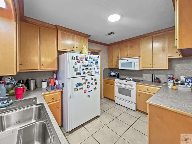 kitchen featuring light tile patterned floors, white appliances, a sink, visible vents, and light countertops