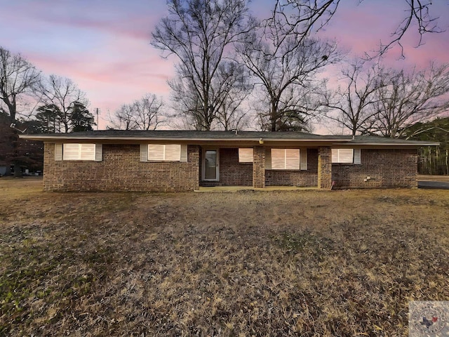 single story home featuring brick siding