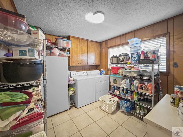 laundry area with wooden walls, washer and clothes dryer, and a wealth of natural light