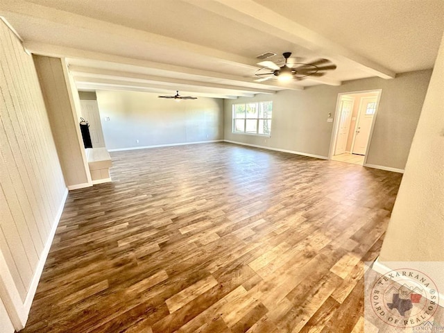 spare room with hardwood / wood-style flooring, beamed ceiling, and ceiling fan