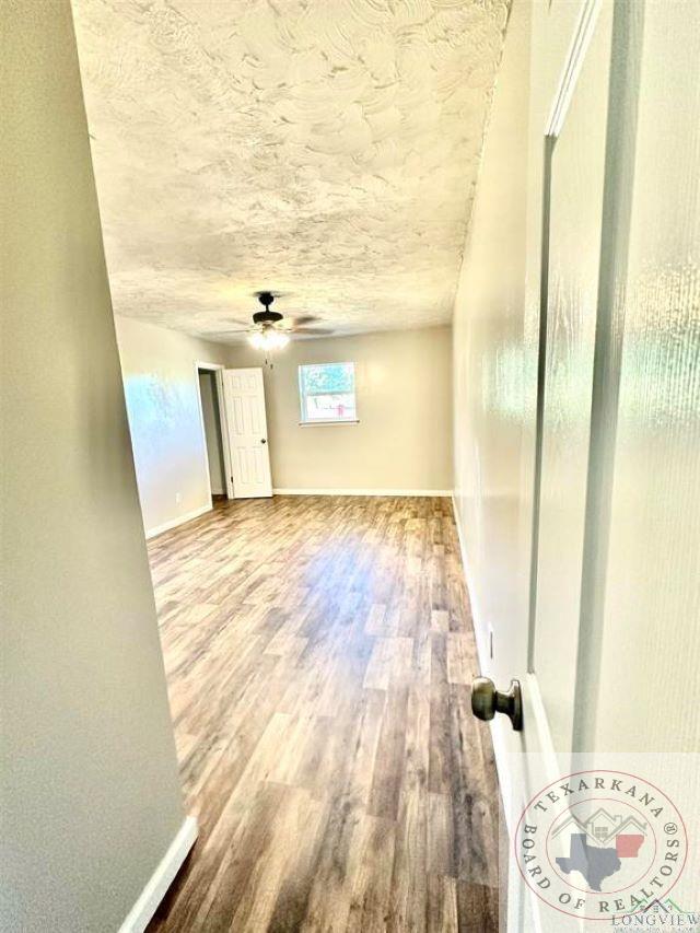 unfurnished room featuring hardwood / wood-style flooring, a textured ceiling, and ceiling fan