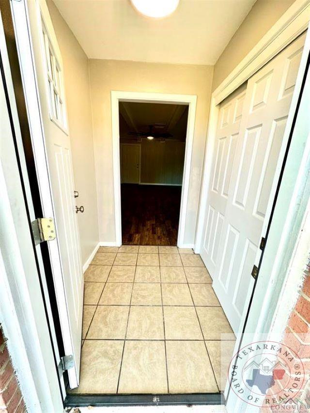 hall with light tile patterned floors