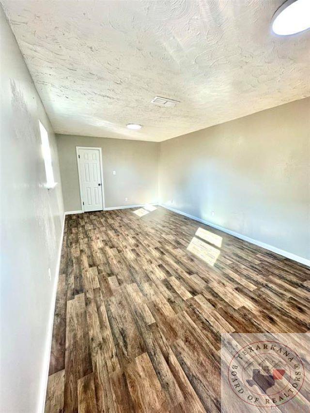 spare room with hardwood / wood-style floors and a textured ceiling