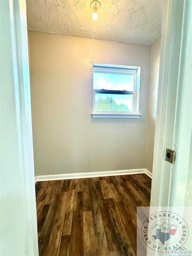 spare room with dark wood-type flooring and a textured ceiling