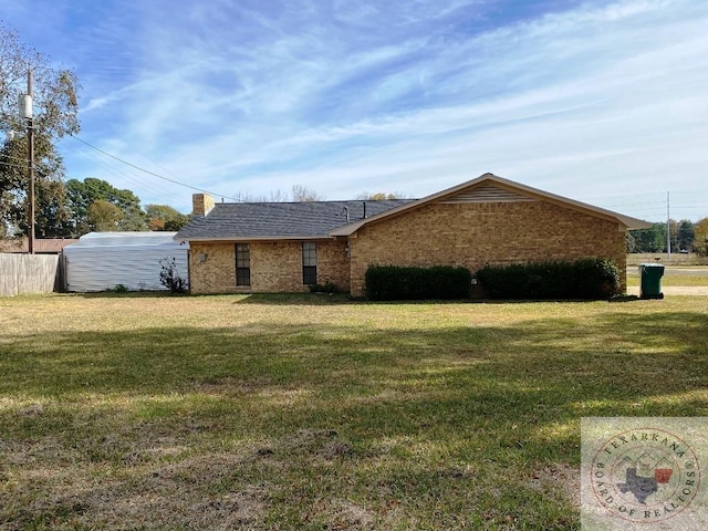 view of side of home with a yard