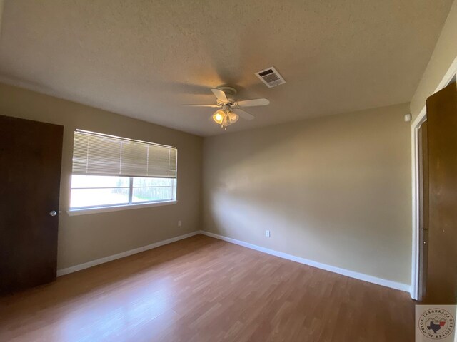 507 E Fannin St, Dekalb, TX 75559 - unfurnished room featuring hardwood / wood-style flooring, a textured ceiling, and ceiling fan