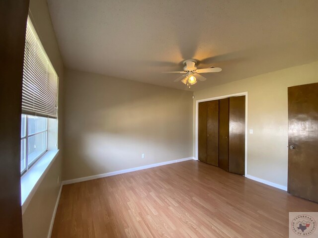 507 E Fannin St, Dekalb, TX 75559 - unfurnished bedroom featuring ceiling fan, a closet, and light wood-type flooring