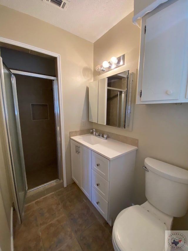 bathroom featuring a textured ceiling, toilet, an enclosed shower, and vanity