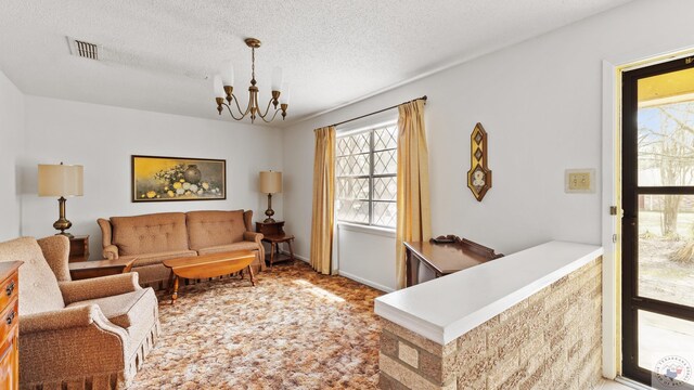 911 S Crestview Dr, Atlanta, TX 75551 - living area featuring a notable chandelier, visible vents, carpet floors, and a textured ceiling