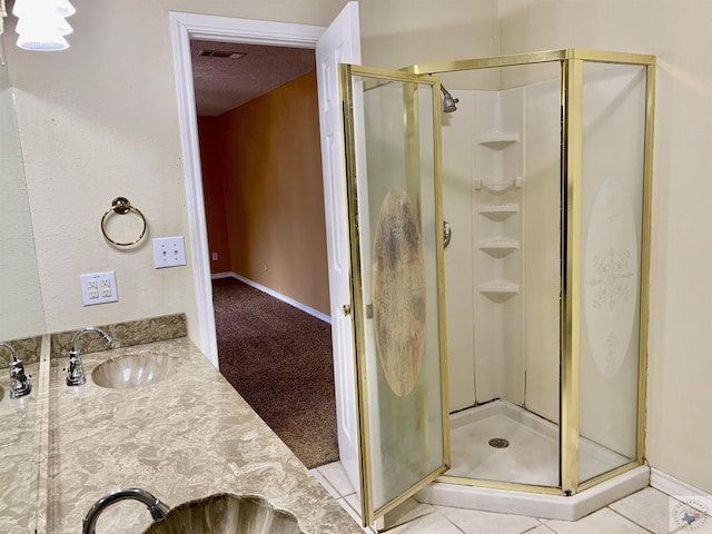 bathroom with vanity, a shower with shower door, and tile patterned flooring