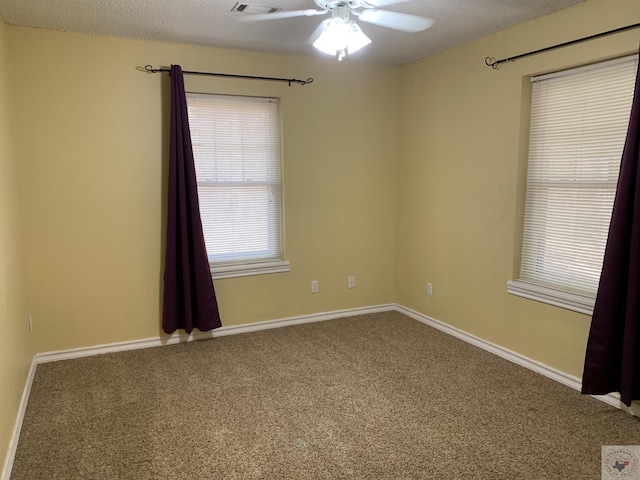 carpeted spare room featuring a textured ceiling and ceiling fan