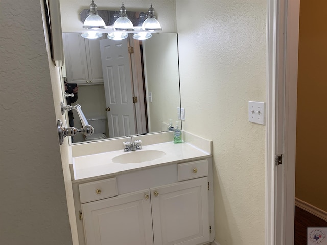 bathroom featuring vanity and a textured wall