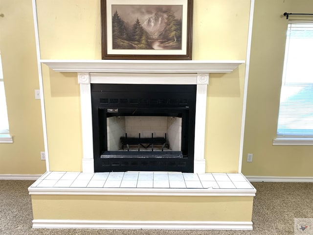 interior details with carpet flooring, baseboards, and a tile fireplace