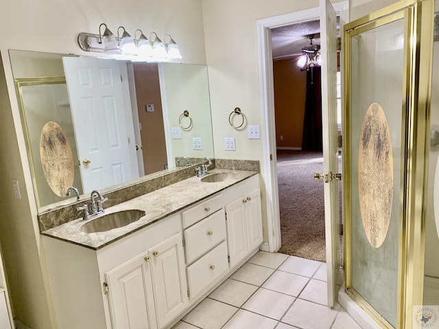 bathroom featuring tile patterned floors, a shower stall, and a sink