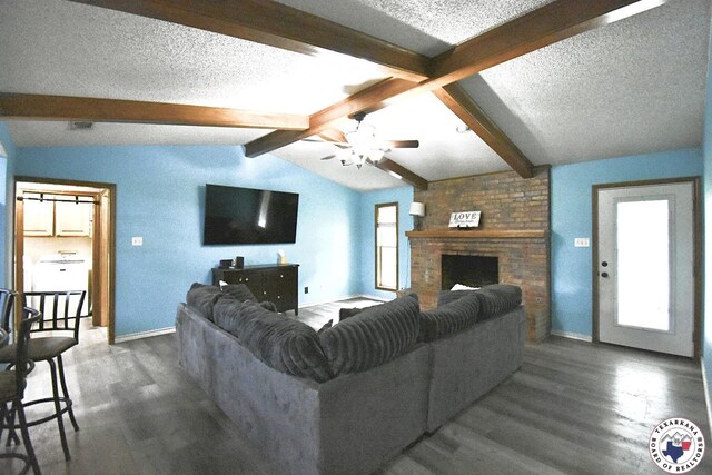 408 Village Ln, Wake Village, TX 75501 - living room with dark wood finished floors, a textured ceiling, ceiling fan, and a fireplace
