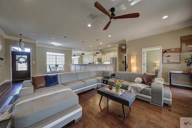 living room with ceiling fan, crown molding, dark hardwood / wood-style floors, and a textured ceiling