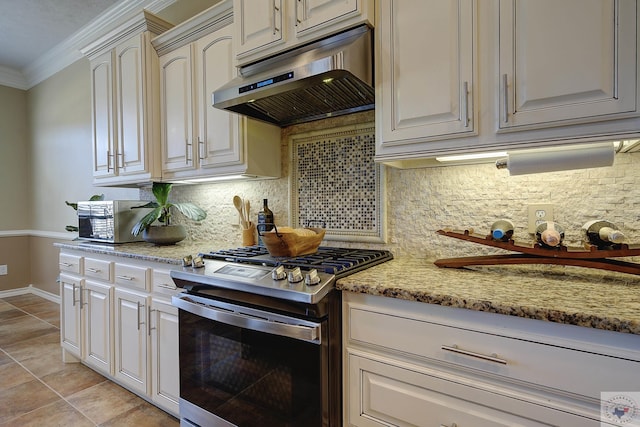 kitchen featuring exhaust hood, tasteful backsplash, light stone counters, stainless steel range with gas cooktop, and crown molding