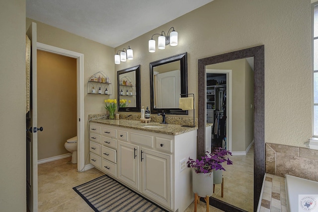 bathroom featuring toilet, vanity, and tile patterned flooring