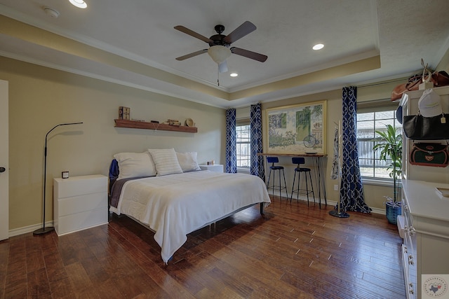 bedroom with ceiling fan, ornamental molding, a tray ceiling, and dark hardwood / wood-style flooring