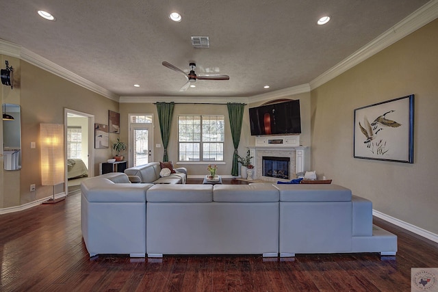 living room featuring ceiling fan, ornamental molding, dark hardwood / wood-style floors, and a textured ceiling